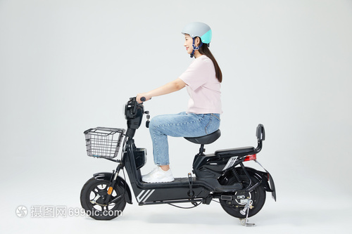 美女戴頭盔騎行電動(dòng)車